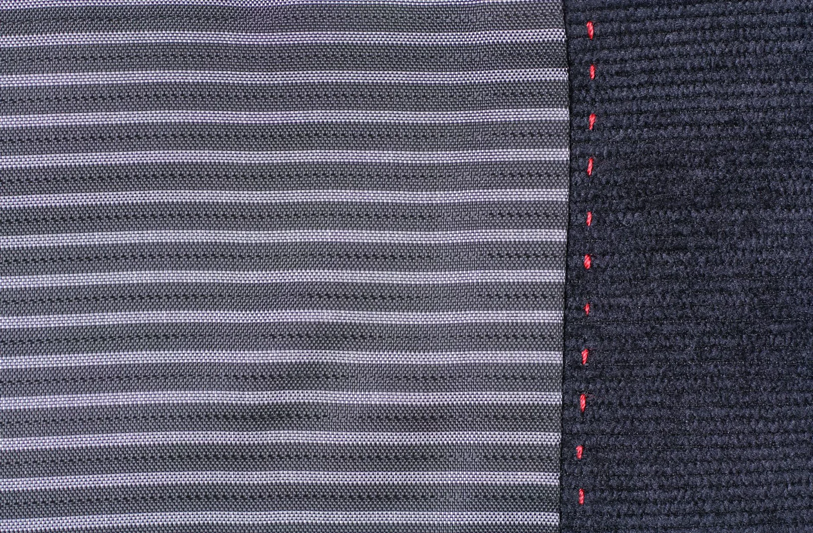 Representative close view of striped fabric with a red stitched edge